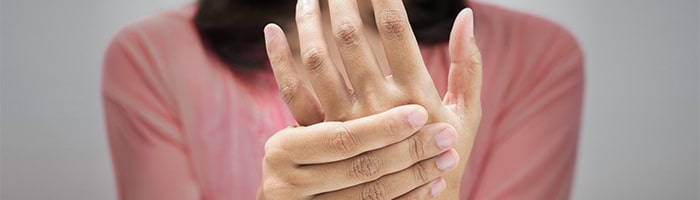 women holding hand due to pain in finger joints - Call Doctor Physiotherapists on Call